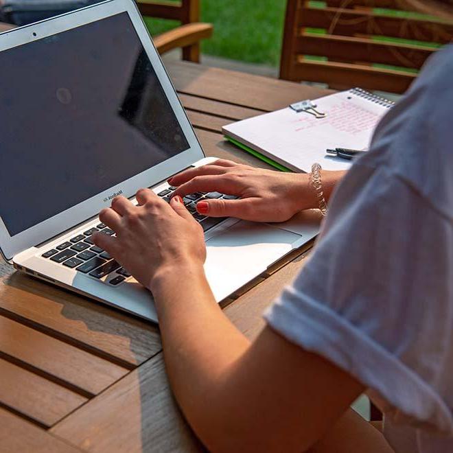 Smiling female student in residence hall studying on laptop